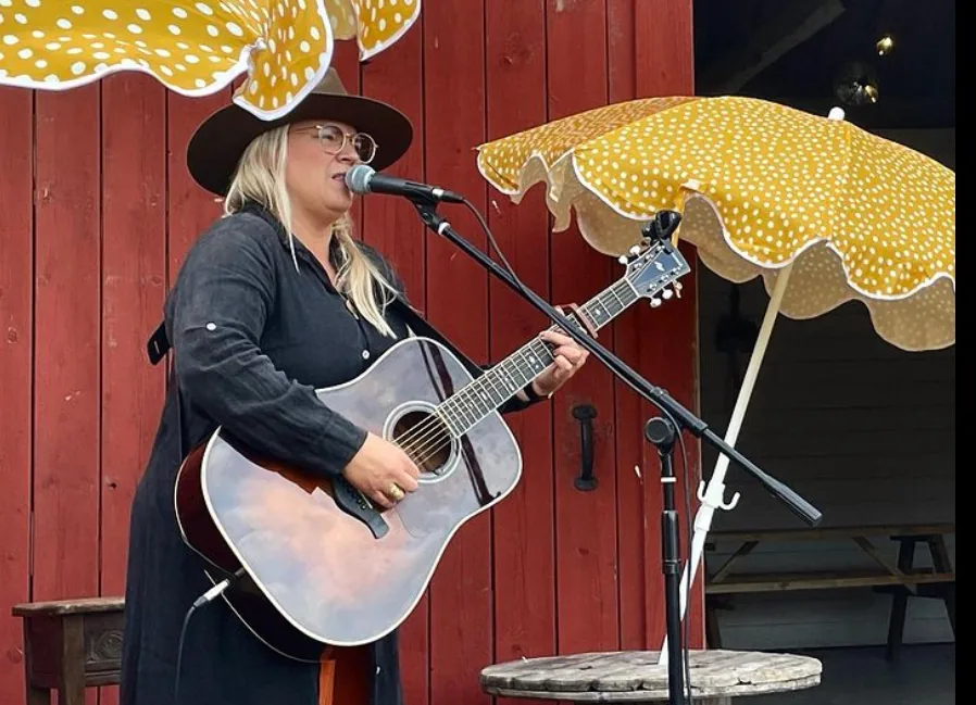 Livemusik under de gula parasollen framför ladan